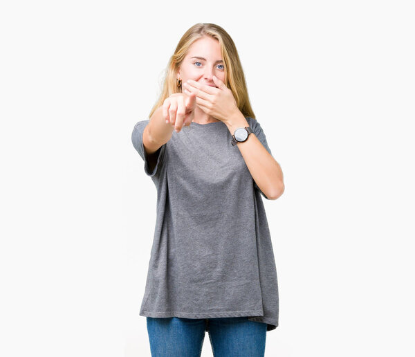 Beautiful young woman wearing oversize casual t-shirt over isolated background Laughing of you, pointing to the camera with finger hand over mouth, shame expression