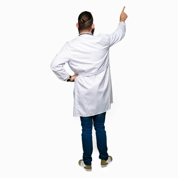 Νεαρό Ξανθιά Γιατρός Άντρας Γένια Φορώντας Ιατρική Παλτό Τοποθέτηση Δείχνοντας — Φωτογραφία Αρχείου