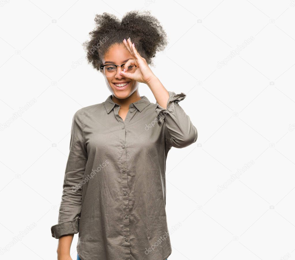 Young afro american woman wearing glasses over isolated background doing ok gesture with hand smiling, eye looking through fingers with happy face.