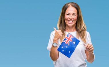 Orta yaş İspanyol kadın holding bayrağı Avustralya izole arka yapıyor ok işareti, kocaman bir gülümseme ile mutlu üzerinde parmak ile mükemmel işareti başparmak