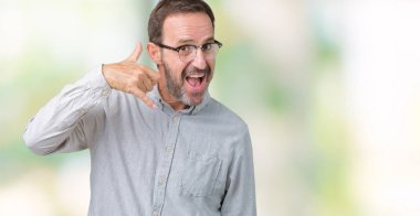 İşin gülümseyen izole arka plan üzerinde gözlük takan yakışıklı orta yaş zarif komuta sizde telefon hareketi ile el ve parmak telefonda konuşuyor gibi. Kavramları iletişim.