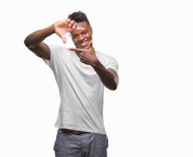 Afrikalı-Amerikalı genç elle yapma çerçeve ve parmakları ile mutlu yüz gülümseyen izole arka plan üzerinde. Yaratıcılık ve Fotoğrafçılık kavramı.