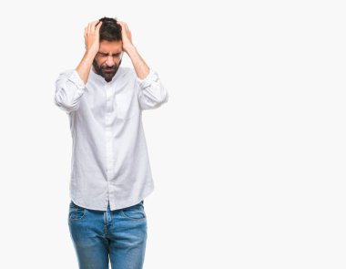 Yetişkin İspanyol adam çünkü umutsuz ve stresli baş ağrısı acı izole arka plan üzerinde ağrı ve migren. Ellerini kafasına.