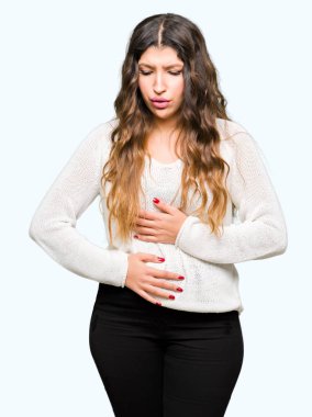 Çünkü mide üzerinde el ile beyaz kazak giyen genç güzel kadın mide bulantısı, ağrılı hastalık hasta hissediyor. Ağrısı kavramı.