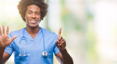 Afro Amerikalı cerrah doktor adam gösterilen ve parmakları ile işaret izole arka plan üzerinde kendinden emin ve mutlu gülümseyerek süre 6 numara.