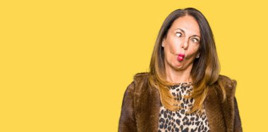 Vizon ceket dudaklı, çılgın ve komik bir jest yapma balık yüz giyen güzel orta yaş zarif kadın. Komik ifade.