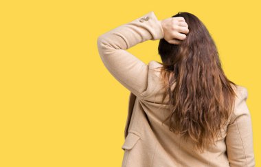 Artı boyutu genç kadın güzel üzerinde kış palto giyiyor arka plan geriye düşünme hakkında şüphe kafasına el ile izole