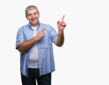 Gülümseyen ve iki elleri ve parmakları ile tarafına işaret kamera bakarak izole arka plan üzerinde üst düzey yakışıklı.