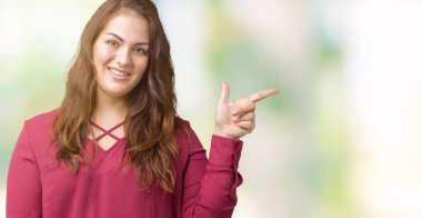 Kameraya bakarak yan el ve parmak ile işaret boyutu genç kadın yüzünde kocaman bir gülümseme ile izole arka plan artı güzel.