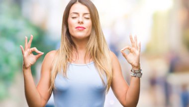 Genç güzel şık iş kadını izole arka plan üzerinde dinlenmek ve gülümseyen gözlerle kapalı parmak jestle meditasyon yapıyor. Yoga kavramı.