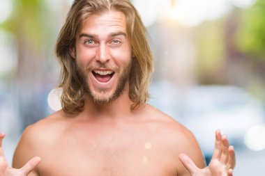 Genç yakışıklı gömleksiz adam uzun saçlı seksi vücut üzerinde gösterilen çılgın kutlama arka plan izole ve başarı için kaldırdı kollarını açarak hayrete ve heyecanlı çığlık gözleri açık. Kazanan kavramı