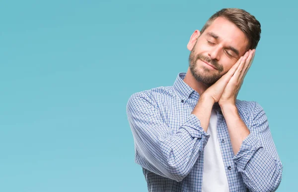 Uyku yorgun hayal ve ellerle birlikte poz ile kapalı gözler gülümseyen izole arka plan üzerinde beyaz t-shirt giyen genç yakışıklı adam.