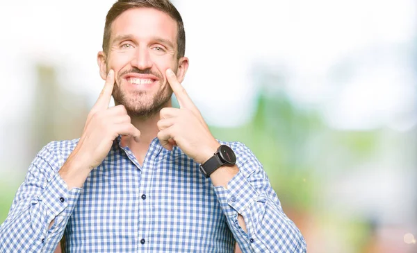 Yakışıklı iş adamı mavi gülen açık ağız ile parmak işaret ve neşeli gülümseme zorlamadan gözleri