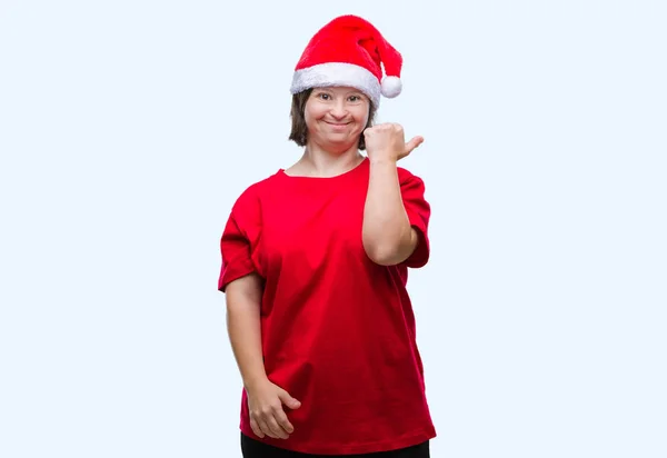 探していると親指側に上向きの幸せそうな顔を浮かべて隔離された背景にクリスマス帽子をかぶっているダウン症候群の若い成人女性 — ストック写真