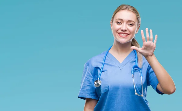 年轻的金发医生 医生的女人在孤立的背景显示和指向与手指数字五 同时微笑着自信和快乐 — 图库照片