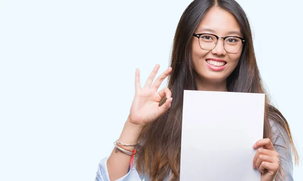 Joven Asiática Sosteniendo Papel Blanco Sobre Aislado Fondo Haciendo Signo —  Fotos de Stock