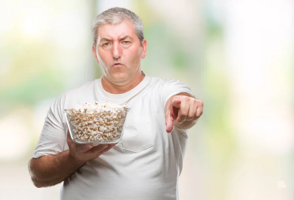 Hombre Mayor Guapo Comiendo Palomitas Maíz Sobre Fondo Aislado Señalando —  Fotos de Stock