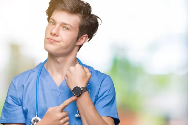 Giovane Medico Uniforme Medica Sfondo Isolato Fretta Indicando Guardare Tempo — Foto Stock