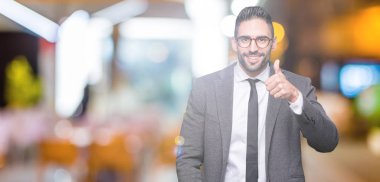 Genç yakışıklı iş adamı mutlu yaşasın el ile jest yapıyor izole arka plan üzerinde. Başarı gösteren kameraya bakarak ifade onaylama.