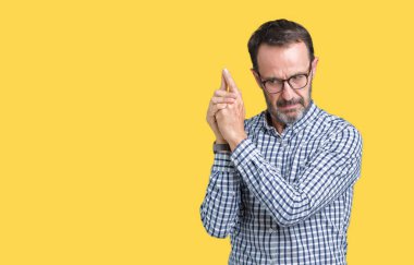 El hareketi ile sembolik silah tutan, çekim silah, kızgın yüz öldürmek oynamaya izole arka plan üzerinde gözlük takan yakışıklı orta yaş zarif komuta sizde