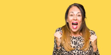 Leopar kutluyor hayvan baskı elbise giyen güzel orta yaş kadın şaşırttı ve başarı için kaldırdı kollarını açarak hayret ve gözleri açık. Kazanan kavramı.