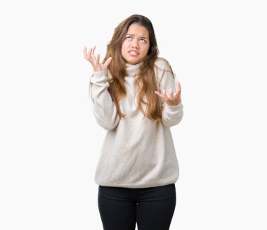 Üzerinde boğazlı kazak giyen genç güzel esmer kadın arka plan deli izole ve deli bağırarak ve agresif ifade ve silah kaldırdı bağırıyor. Hayal kırıklığı kavramı.