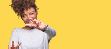 Güzel genç Afro-Amerikan kadın parmaklarını zafer işareti yaparken gösterilen kamera seyir gülümseyen izole arka plan yüzünden. İki numaralı.