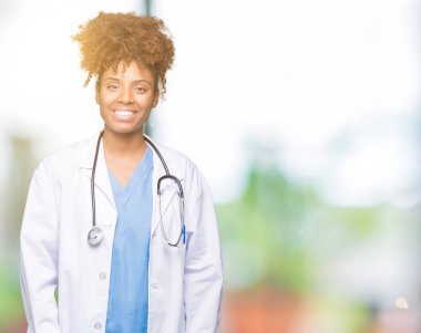 Genç Afro-Amerikan doktor kadın yüzünde mutlu ve güzel bir gülümseme ile izole arka plan yüzünden. Şanslı kişi.