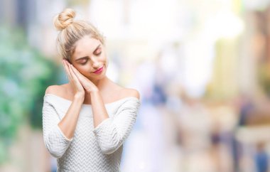 Genç güzel sarışın ve mavi gözlü kadın yüzünden uyku yorgun hayal ve ile gülümseyen gözleri kapalı iken ellerle birlikte poz izole arka plan.