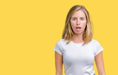 Casual beyaz giyen güzel genç kadın şüpheci ve alaycı, t-shirt üzerine şok karşısında izole arka plan açık ağız ile şaşırttı.