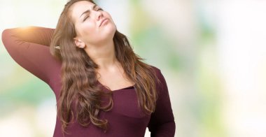 Güzel ve çekici giyen boyutu genç kadın artı izole arka plan germe üzerinde bir elbise geri, yorgun ve rahat, Uykulu ve erken sabah esneme