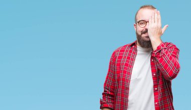 Üzerinde gözlük takan Genç beyaz hipster adam arka plan kapsayan bir göz yüz ve sürpriz duygu kendinden emin gülümseme ile el ile izole.