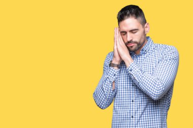 Yakışıklı delikanlı uyku yorgun hayal ve ellerle birlikte poz ile kapalı gözler gülümseyen izole arka plan üzerinde.