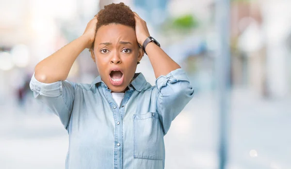 Young beautiful african american woman over isolated background Crazy and scared with hands on head, afraid and surprised of shock with open mouth