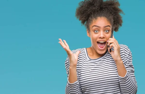 Young afro american woman talking on the phone over isolated background very happy and excited, winner expression celebrating victory screaming with big smile and raised hands