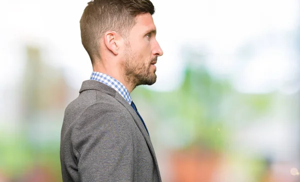 Handsome business man wearing suit and tie looking to side, relax profile pose with natural face with confident smile.