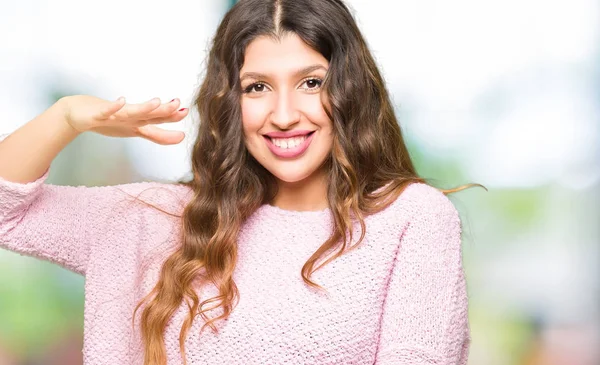 年轻美丽的女人穿着粉红色的毛衣 双手花大 大尺寸的标志 测量符号 看着镜头微笑 测量概念 — 图库照片
