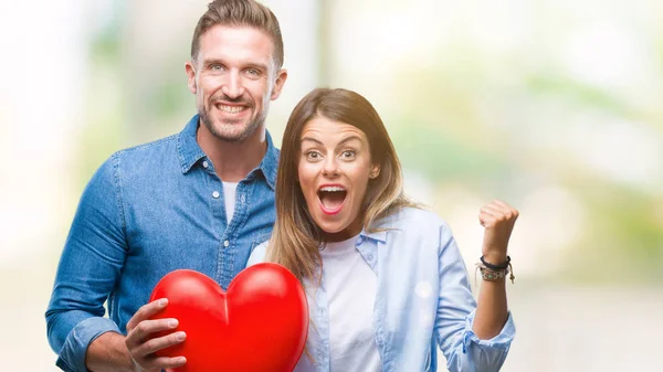 Pareja Joven Enamorada Sosteniendo Corazón Rojo Sobre Fondo Aislado Gritando — Foto de Stock