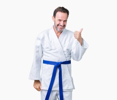 Yakışıklı orta yaş komuta sizde kimono üniforması üzerinde arka plan hareketi el ile mutlu yaşasın yapıyor izole. Başarı gösteren kameraya bakarak ifade onaylama.