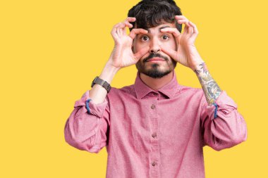 Yakışıklı delikanlı ile parmak, Uykulu ve sabah yorgunluk için yorgun gözlerini açmaya çalışırken izole arka plan üzerinde pembe gömlek giymiş