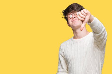 Mutsuz ve kızgın ret gösterilen ve başparmak aşağı hareketi ile negatif seyir izole arka plan üzerinde gözlük takan yakışıklı delikanlı. Kötü ifade.