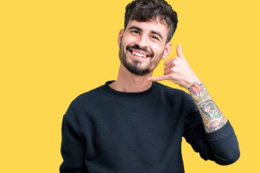 Yakışıklı delikanlı yapıyor gülümseyen izole arka plan üzerinde telefon hareketi ile el ve parmak telefonda konuşuyor gibi. Kavramları iletişim.