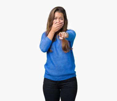 Mavi kazak izole üzerinde giyen genç güzel esmer kadın arka plan sizin parmak el kamerasıyla ağzına, utanç ifadesi işaret eden gülme