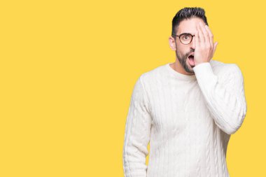El yüz ve sürpriz duygu kendinden emin gülümseme ile tek gözüyle kapsayan izole arka plan üzerinde gözlük takan genç yakışıklı adam.