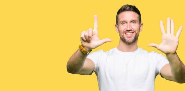 Yakışıklı adam gösterilen ve parmakları ile işaret casual beyaz t-shirt giyen kendinden emin ve mutlu gülümseyerek süre yedi numara.