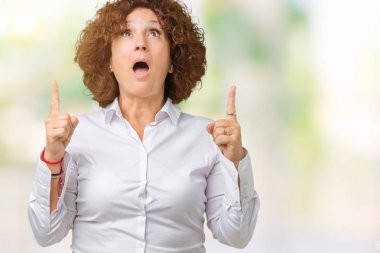 Güzel orta ager üst düzey businees kadın izole arka plan üzerinden hayran ve yukarıya bakıp parmakları ile işaret şaşırttı ve silah kaldırdı.