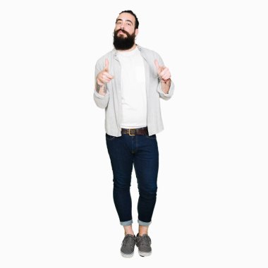 Uzun saç, sakal ve fotoğraf makinesi ile mutlu ve komik yüz için parmakları işaret küpe olan genç adam. İyi enerji ve vibes.