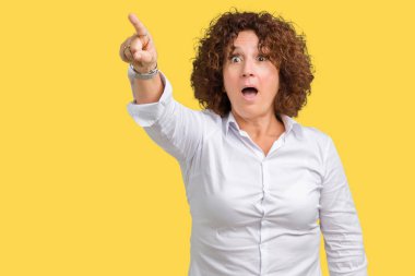 İzole arka plan ile sürpriz devam et, parmakla üzerinde güzel orta ager üst düzey businees kadın ağzı açık ifade, önünde bir şey hayret