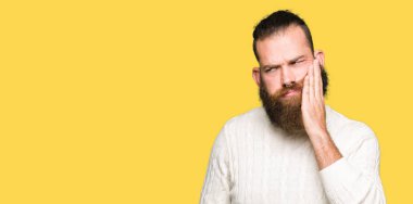 Diş ağrısı veya dişlerde dişlerle ilgili hastalık nedeniyle ağız acı ifadesi ile el ile dokunmak kış kazak giyen genç hipster adam. Diş hekimi kavramı.