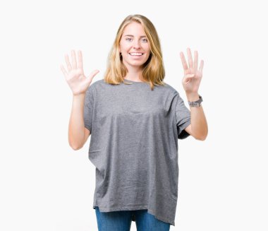 Gösterilen ve parmakları ile işaret izole arka plan üzerinde büyük boy rahat t-shirt giyen güzel genç kadın numara 9 kendinden emin ve mutlu gülümseyerek süre.